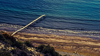 Aerial View of Wooden Jetty Extending into Blue Sea at Zapalo Beach