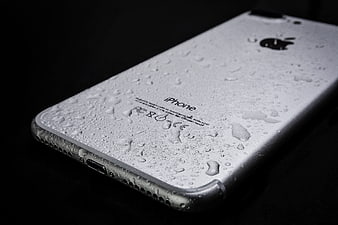 Close-up of wet silver iPhone on black background