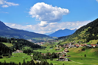 Alpine Village Panorama With Green Meadows And Blue Sky