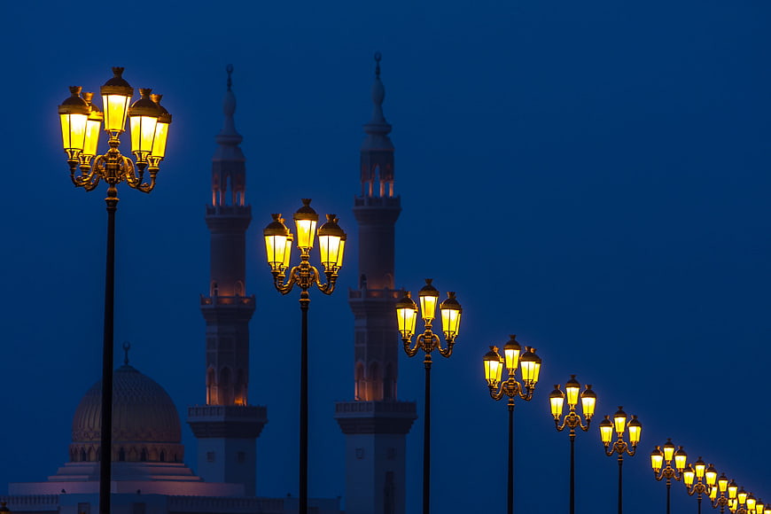 Illuminated Street Lamps and Mosque Minarets at Blue Hour