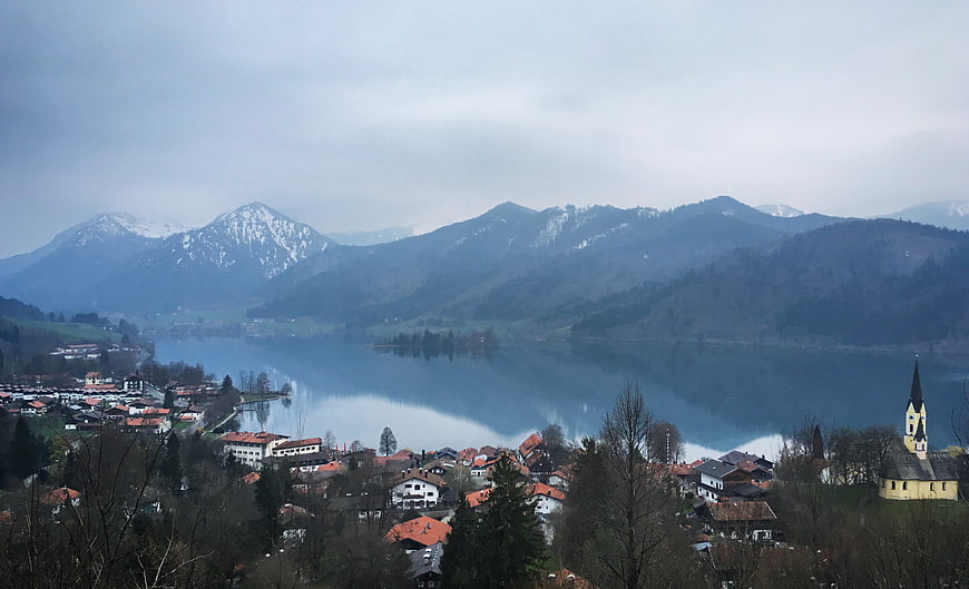 Scenic Alpine Village by Lake with Snow-Capped Mountains