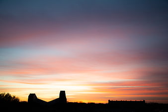 Silhouette of modern buildings against a vibrant sunset sky