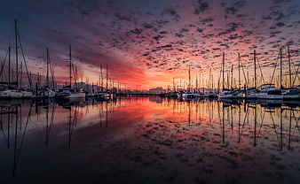 Sailboats in Marina at Vibrant Sunset with Reflections