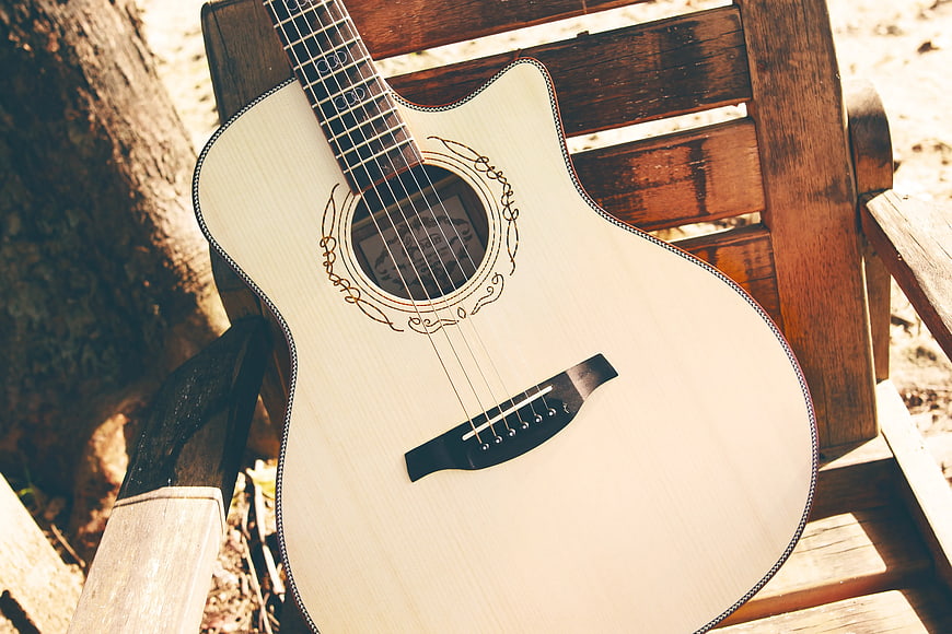 White Acoustic Guitar on Wooden Bench Outdoors