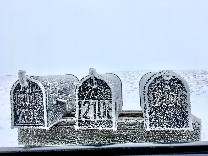 Snow-covered rural mailboxes in winter landscape