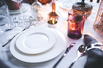 Elegant Holiday Table Setting with Amber Candle and White Linens