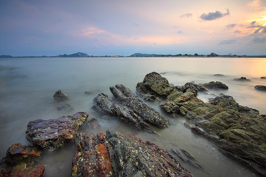 Long Exposure Rocky Coastline at Sunset with Misty Water