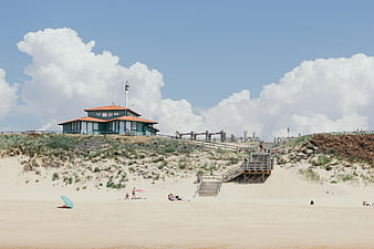 Beach House on Dunes with Wooden Stairs and Blue Sky