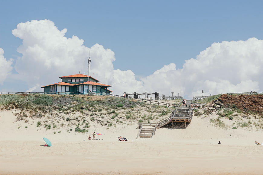 Beach House on Dunes with Wooden Stairs and Blue Sky