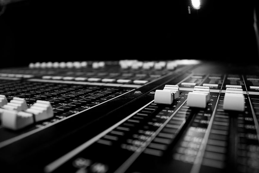 Close-up of professional audio mixing console faders and controls