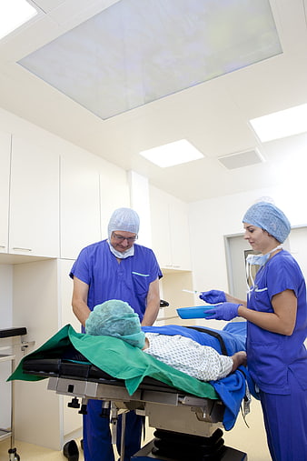 Surgeons Preparing Patient For Surgery In Modern Operating Room