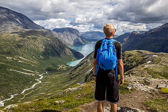 Senior Hiker With Blue Backpack Overlooking Norwegian Fjord Landscape