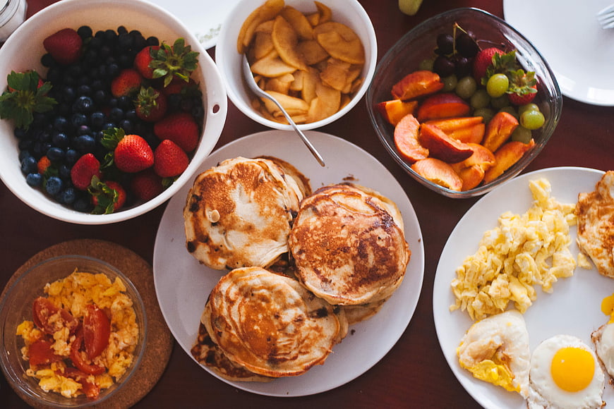 Overhead view of healthy breakfast spread with pancakes and fruit