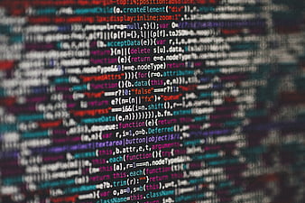 Blurred colorful computer programming code on dark background
