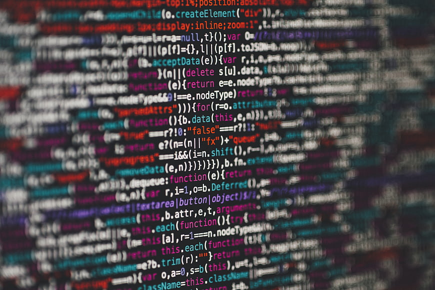 Blurred colorful computer programming code on dark background