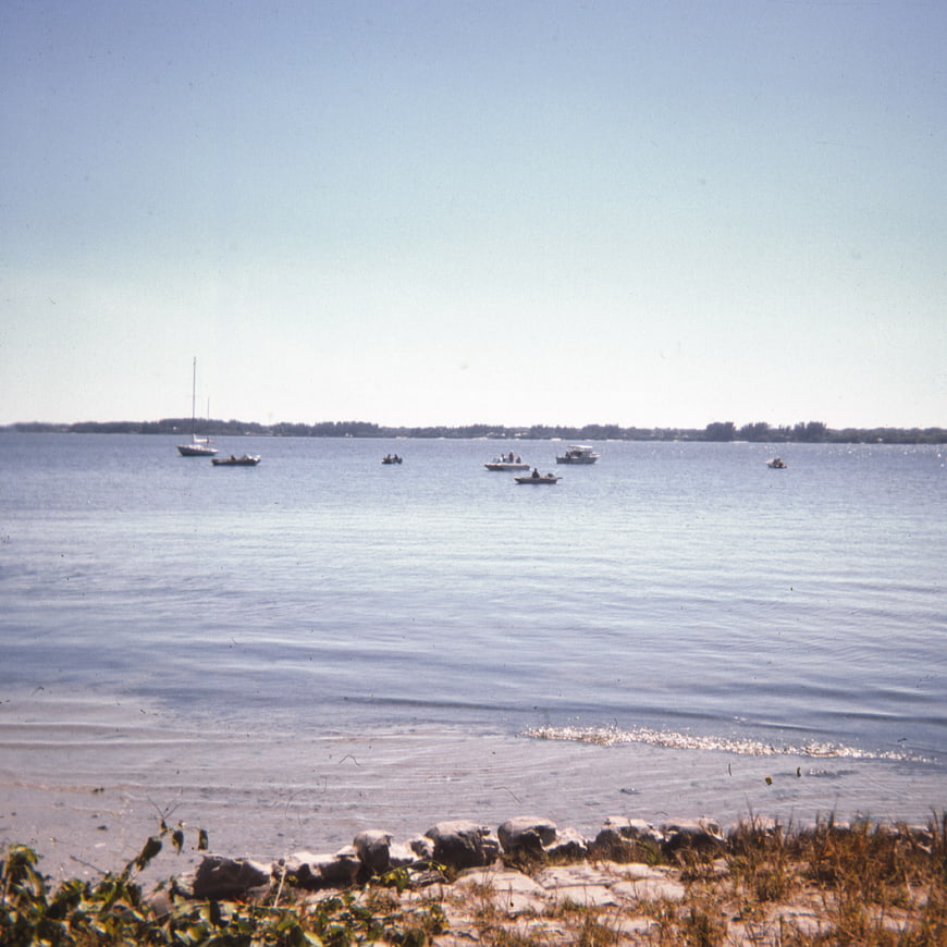 Vintage film photo of boats on calm blue lake