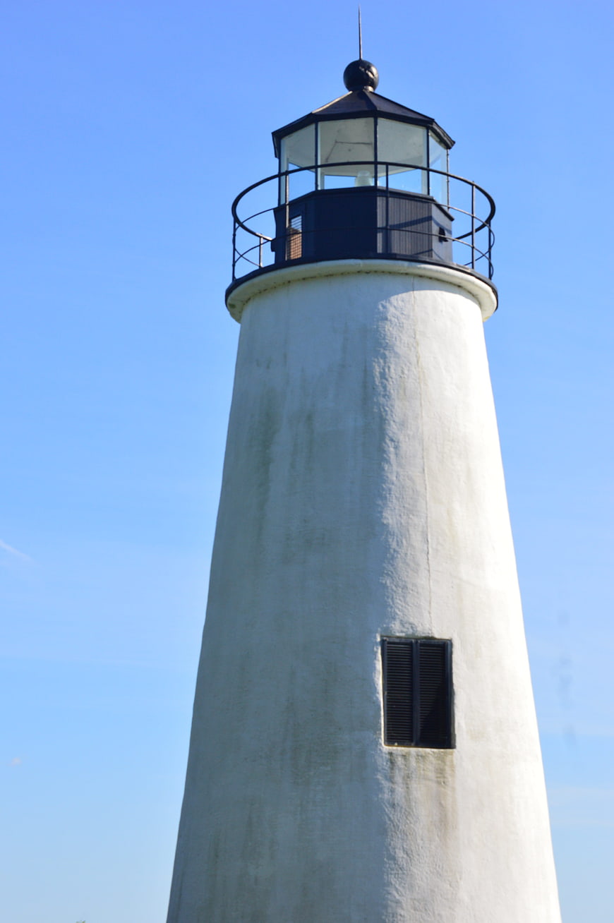 White Lighthouse Tower Against Clear Blue Sky