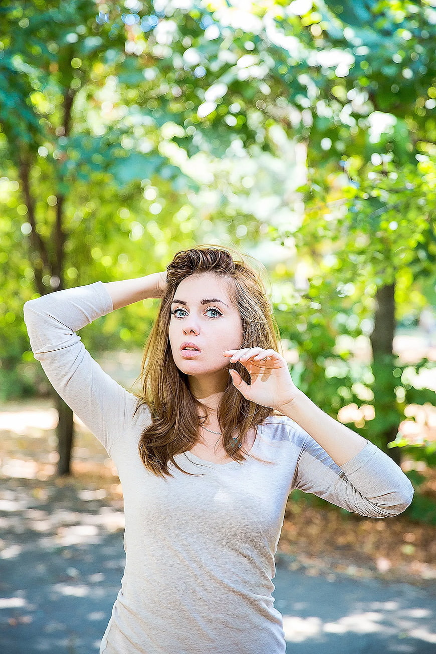 Young Woman in Park with Hands in Hair