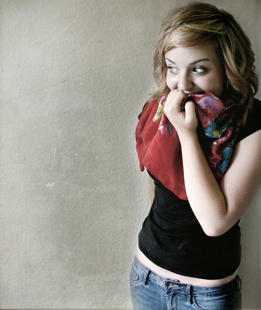 Young woman laughing with floral scarf against beige wall