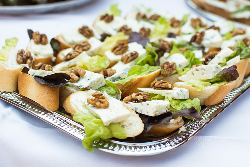 Blue cheese and walnut crostini appetizers on silver tray