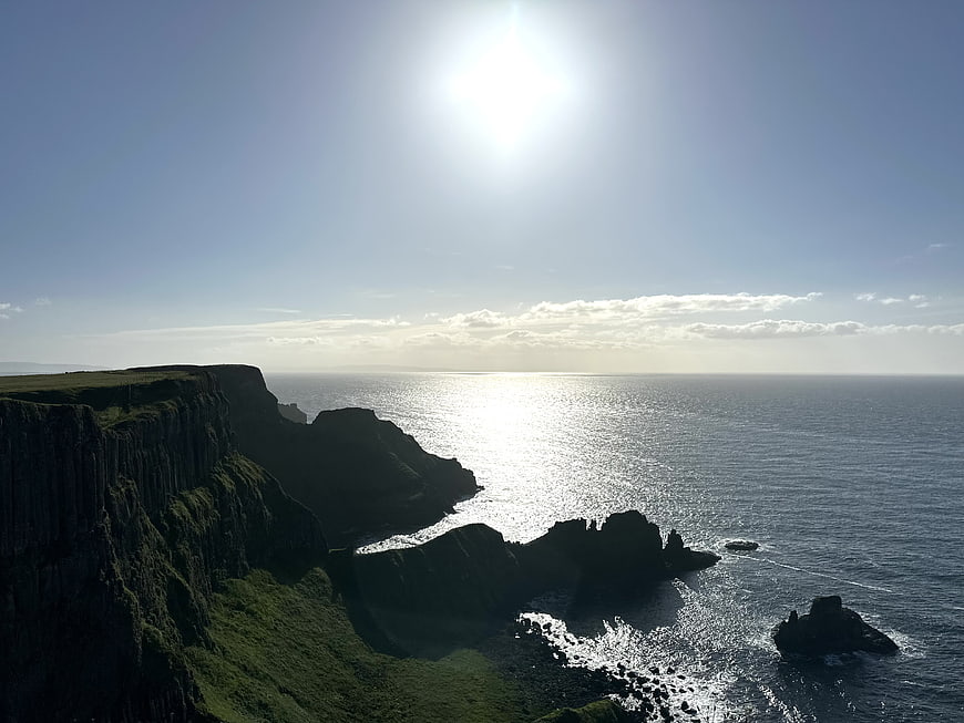 Dramatic Coastal Cliffs Overlooking Shimmering Ocean at Sunset