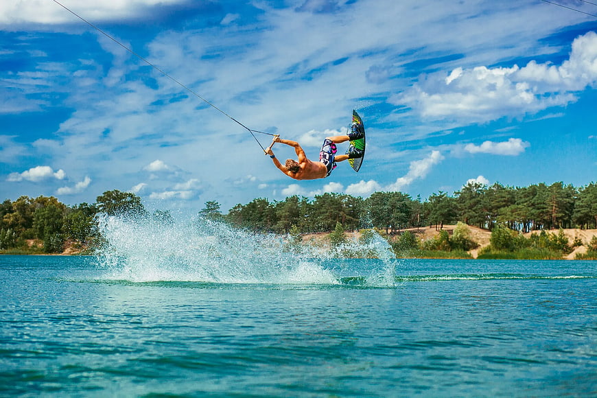 Man performing wakeboarding jump on lake