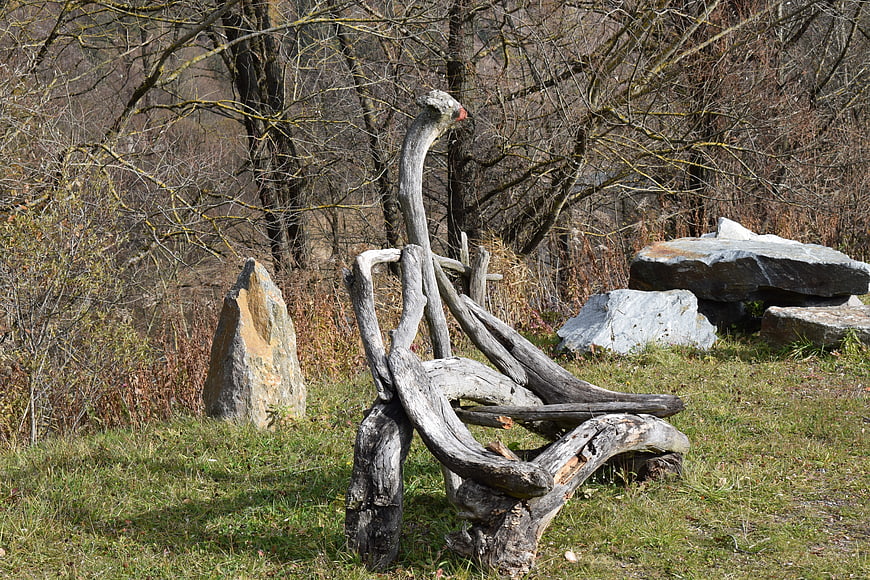 Rustic Driftwood Sculpture Bench in Natural Park Setting