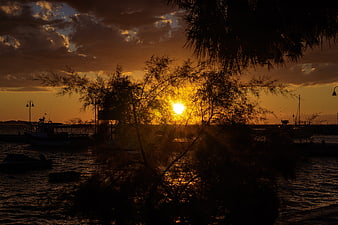 Golden Sunset Silhouette Over Harbor With Boats