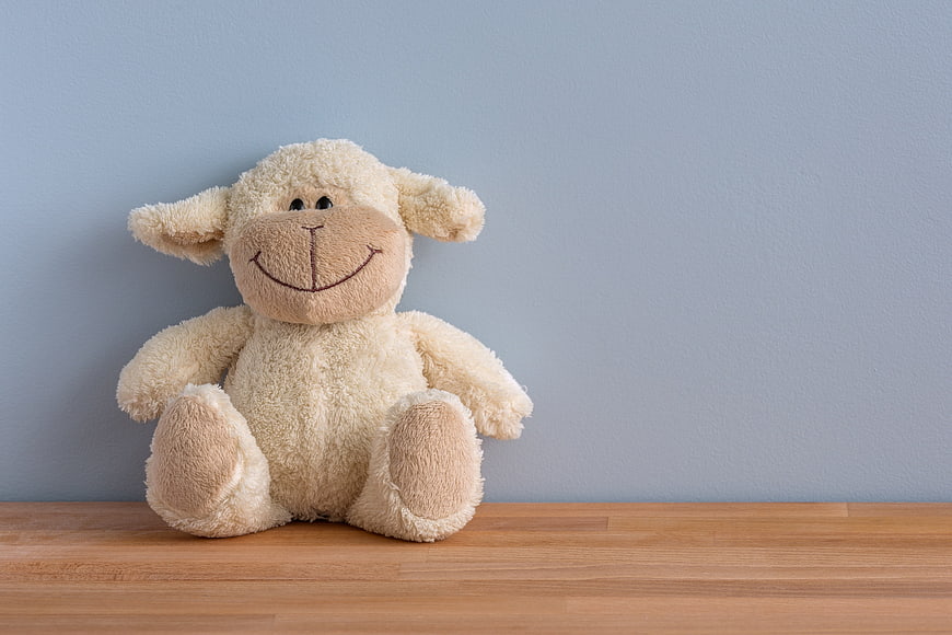 Cute Smiling Plush Sheep Toy on Wooden Shelf