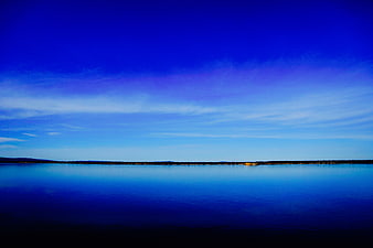 Serene Blue Lake Landscape with Distant Shoreline