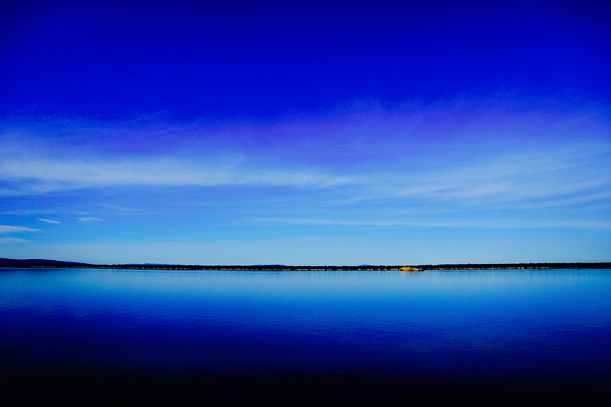 Serene Blue Lake Landscape with Distant Shoreline