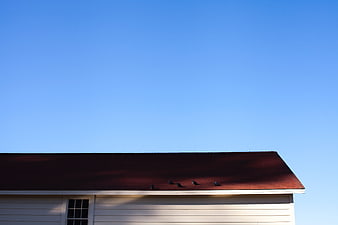 Minimalist house roof with birds against clear blue sky