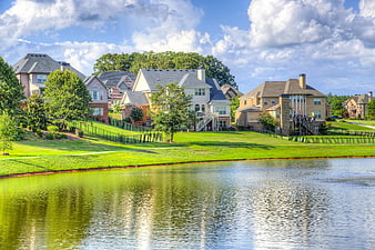 Suburban Lakefront Homes With Lush Green Lawns And Blue Sky