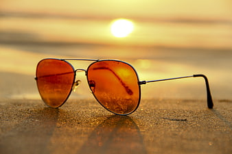 Aviator Sunglasses on Sandy Beach at Golden Sunset