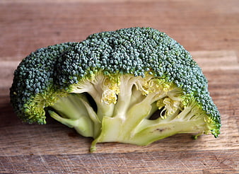 Fresh Cut Broccoli Head on Rustic Wooden Cutting Board