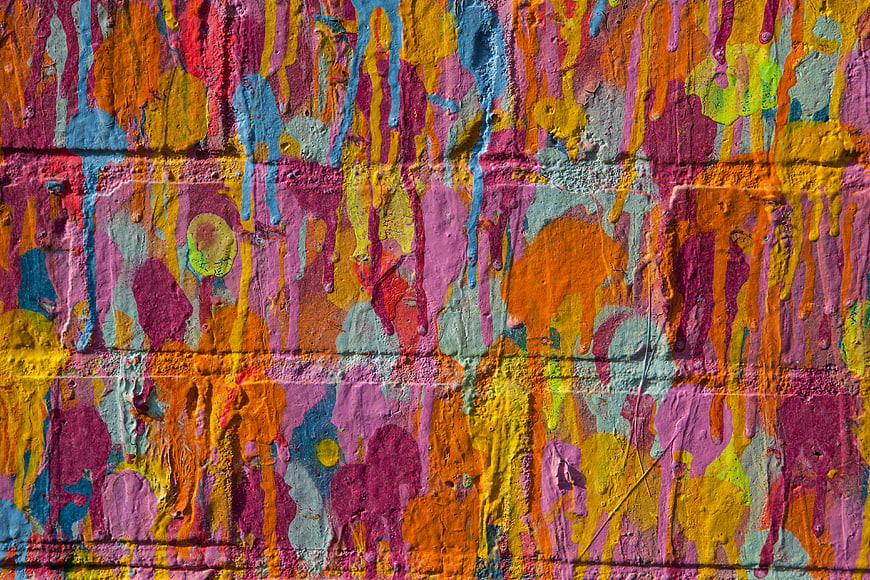 Vibrant Multi-Color Paint Splatter on Textured Wall