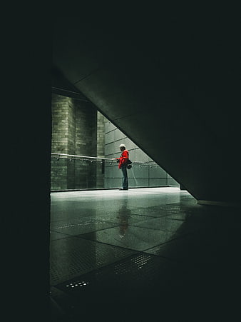 Senior man in red jacket standing in modern architectural space