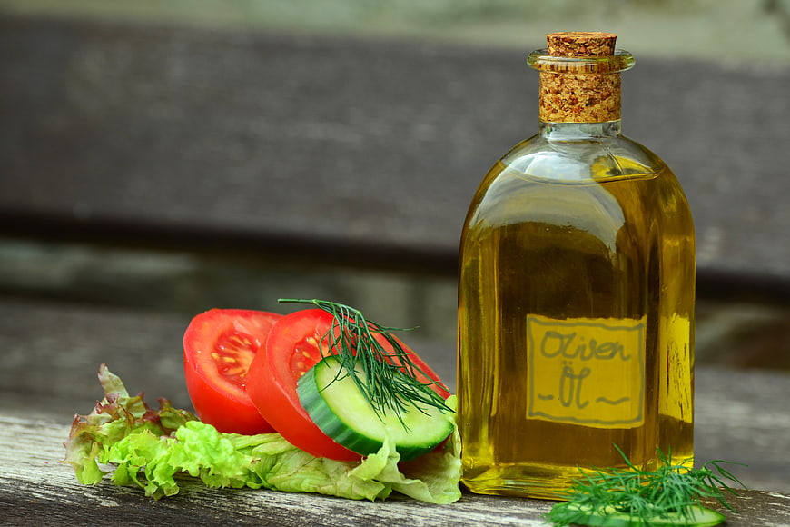 Glass Bottle of Olive Oil with Fresh Salad Ingredients