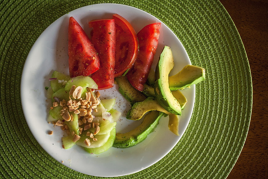 Overhead view of fresh avocado and tomato salad with nuts