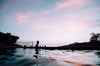 Couple Relaxing in Infinity Pool at Sunset