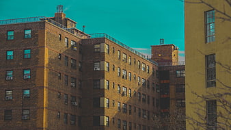 Urban brick apartment building with teal sky