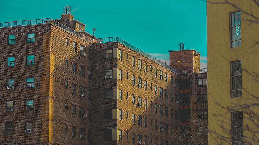 Urban brick apartment building with teal sky