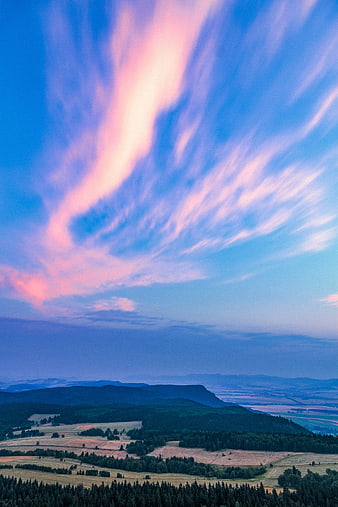 Dramatic Pink and Blue Sunset Clouds Over Rolling Hills