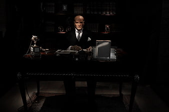 Dramatic Portrait of Man in Suit at Dark Executive Desk