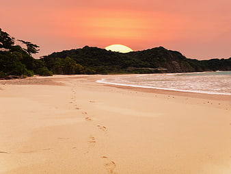 Tropical Beach Sunset with Footprints in Sand