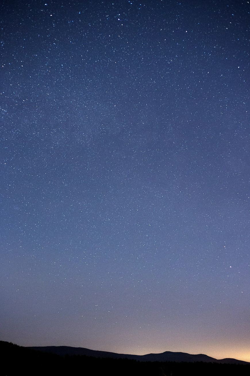 Starry Night Sky Over Silhouette Mountains