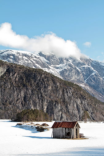 Rustic wooden cabin in snowy mountain landscape