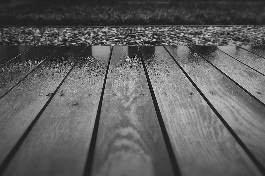 Black and white wet wooden deck planks with raindrops