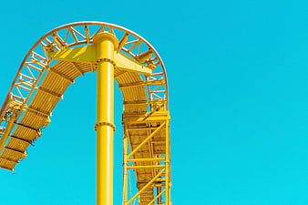 Yellow Roller Coaster Loop Against Blue Sky