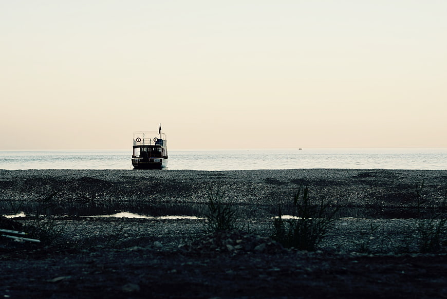 Lone boat stranded on pebble beach at dusk